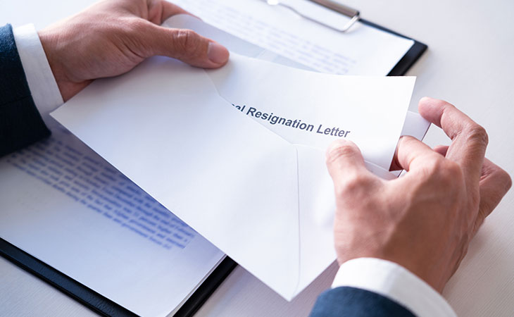 How To Write A Resignation Letter: Step-By-Step Guide Evinex Corporation | Staffing Agency detail of hands opening a resignation letter