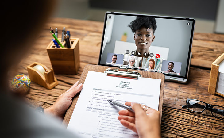 Interview Cheat Sheet: Essential Tips To Ace Your Interview Evinex Corporation | Staffing Agency detail of womans hands while reading papers and a tablet showing a video call