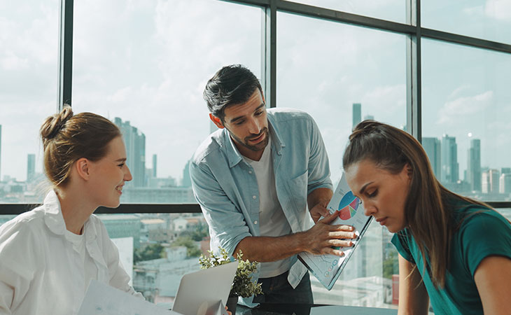What Is Teamwork And Why Is It Important For Success? Evinex Corporation | Staffing Agency three people of which a man is holding papers