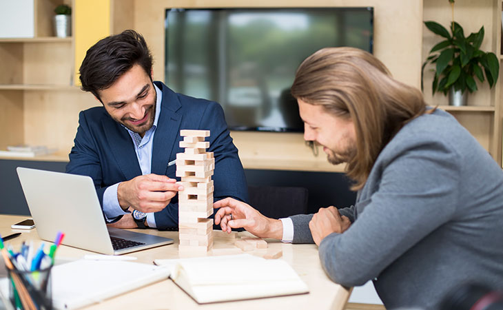 What Is Teamwork And Why Is It Important For Success? Evinex Corporation | Staffing Agency two businessmen playing jenga