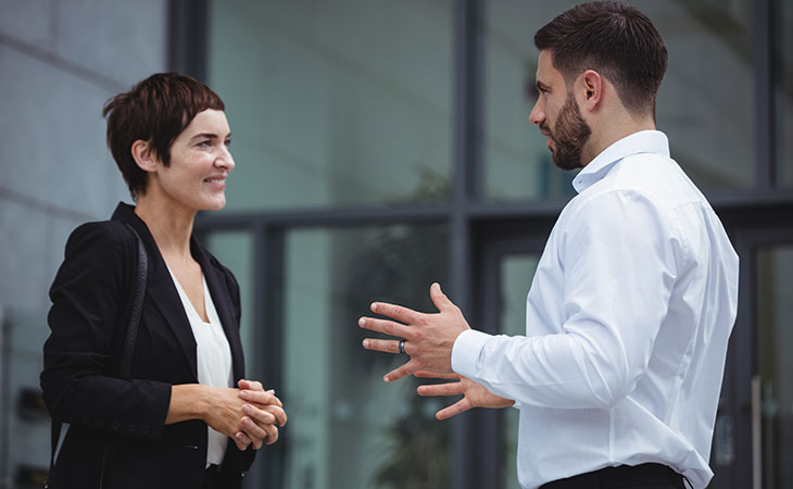 two professionals are talking outside